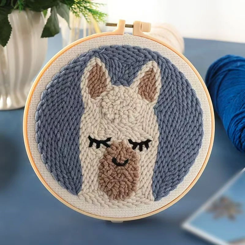 Alpaca wall art punch needle kit showing cute white alpaca design in embroidery hoop with yarn and crafting tools