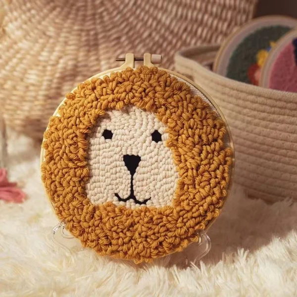Little lion punch needle design kit with adorable lion face pattern in wooden hoop, yarn, and beginner crafting materials