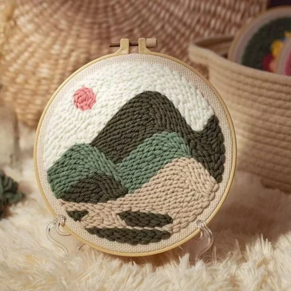 Mountain landscape punch needle starter kit featuring rolling hills and peaks design in wooden hoop with yarn and crafting tools