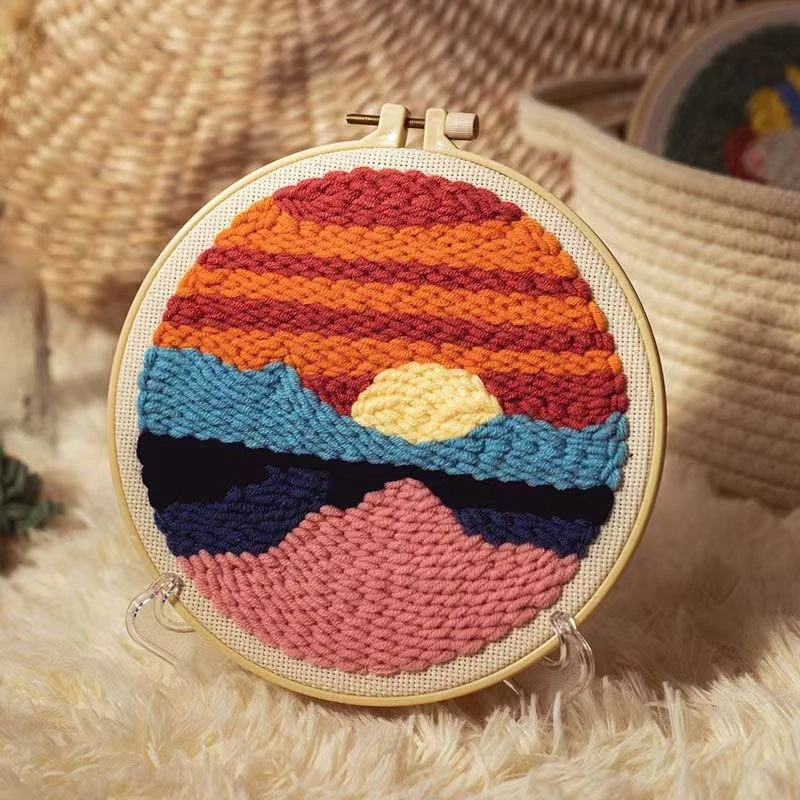 Sunset art punch needle embroidery kit with colorful gradient design in wooden hoop, yarn, and beginner supplies