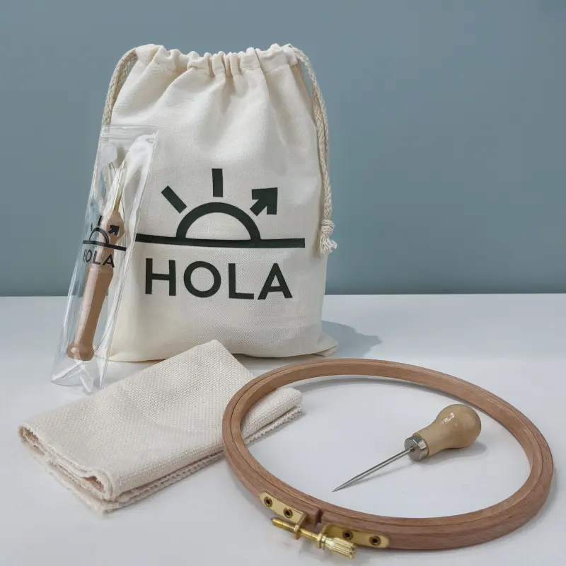 Punch needle hoop kit contents showing wooden embroidery hoop needle tool fabric and branded storage bag
