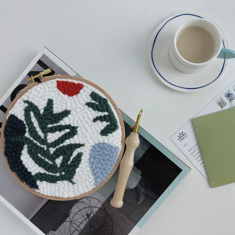 Punch needle embroidery wild leaves design displayed with coffee cup and magazines in cozy lifestyle crafting scene