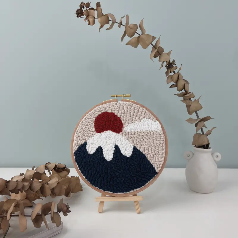 Mount Fuji art punch needle finished wall decor displayed on wooden easel with eucalyptus branches home styling