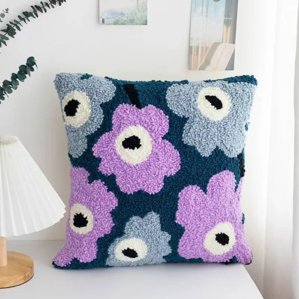 Purple flowers punch needle pillow kit showing finished cushion with floral design and crafting materials