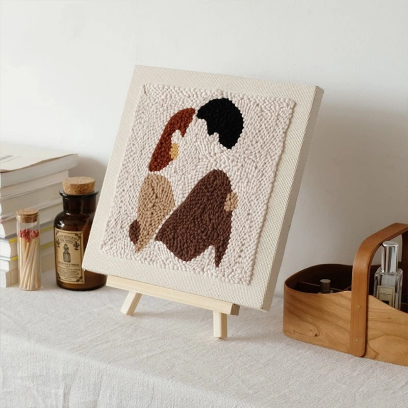 DIY couple gift punch needle wall art showing abstract couple silhouettes in earth tones on white fabric with easel