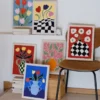 Multiple DIY wall decor punch needle artworks displayed together showing different vase and flower designs in vibrant colors