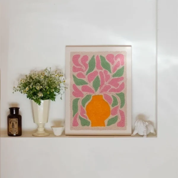 DIY yarn wall art kit featuring an orange vase and flowers — relaxing punch needle project for cozy handmade home decor.