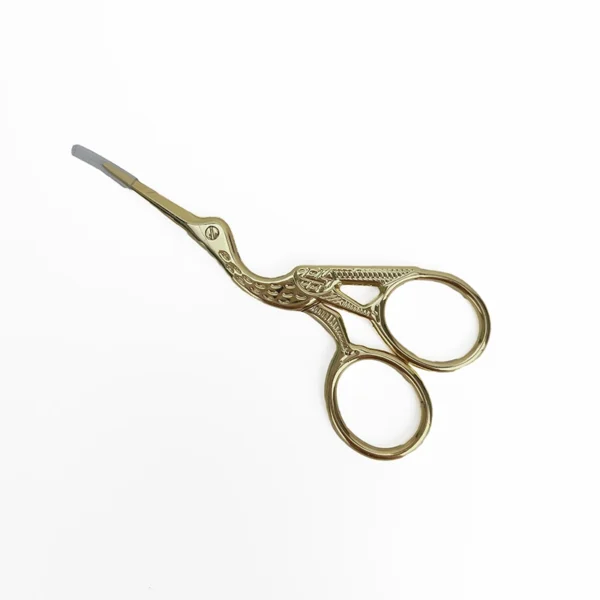 Close-up view of ornate gold stork embroidery scissors showing detailed craftsmanship and elegant curved design