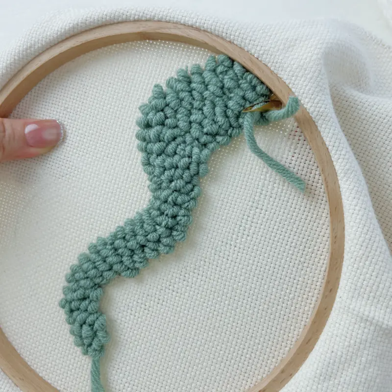 Back view of green block – loops uniform, yarn tail ~3–5 cm left before trimming